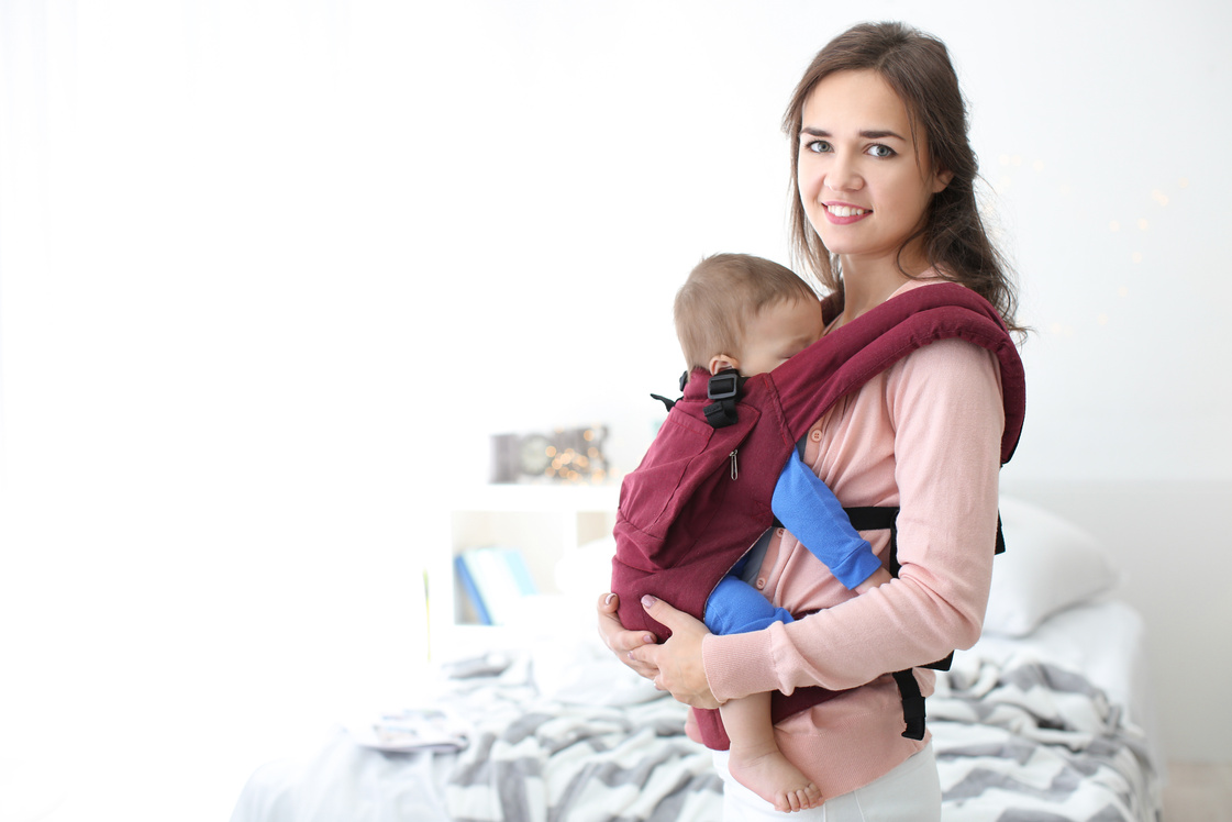 Lovely Mother with Baby in Baby Carrier at Home